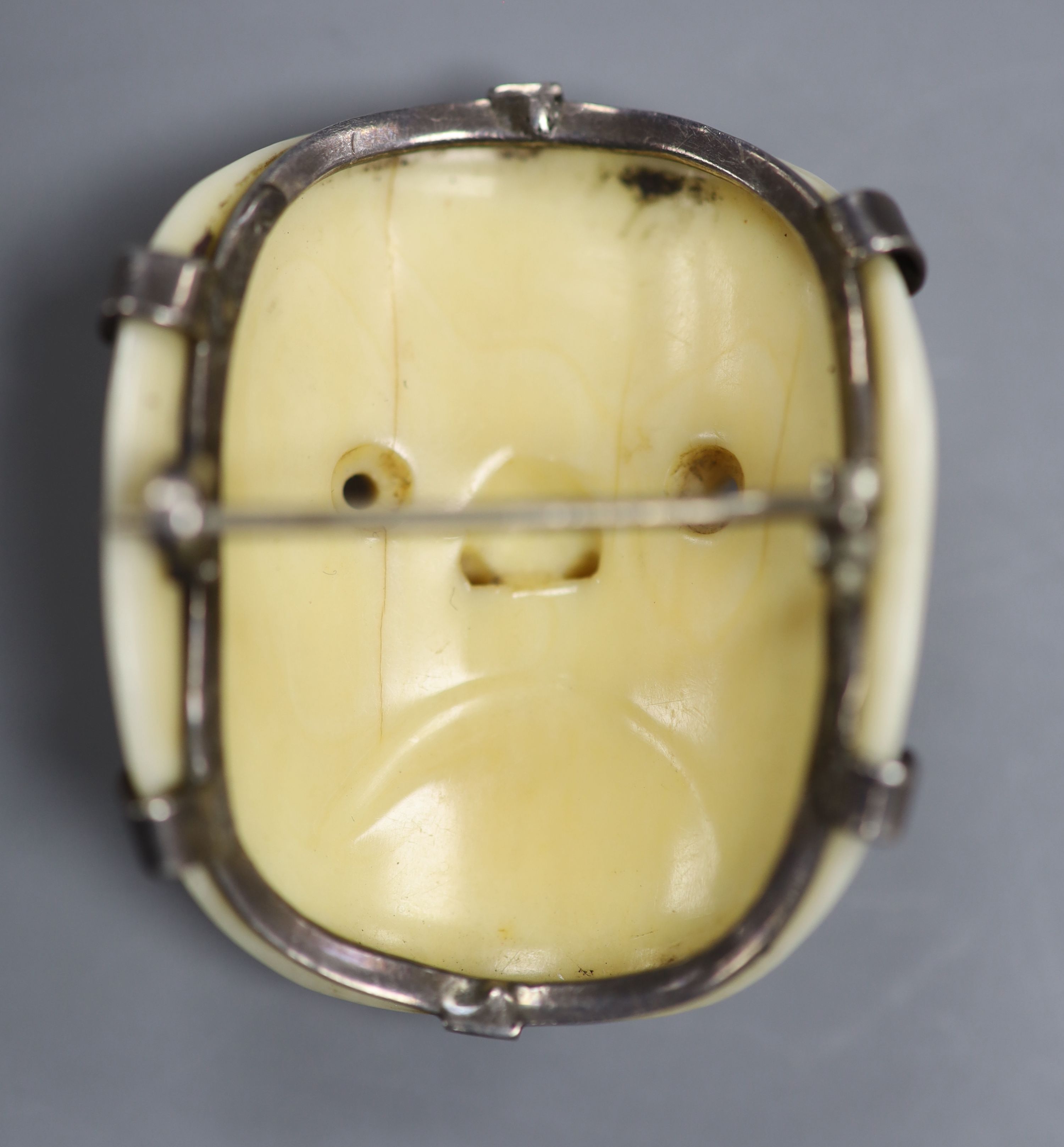 A 19th century Japanese carved ivory Noh mask netsuke mounted as a brooch, 4cm